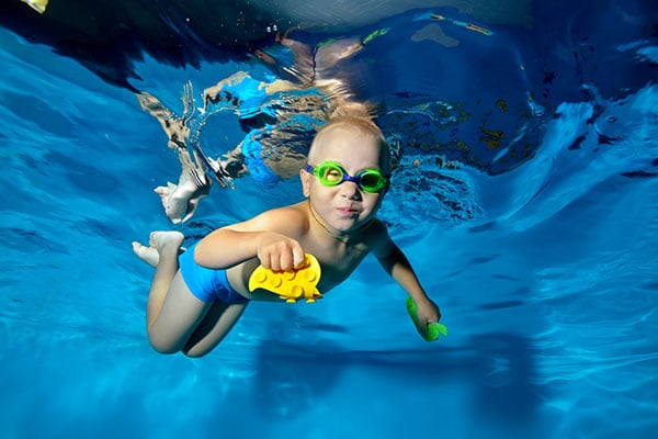 Happy child engaged in sports swimming in the pool